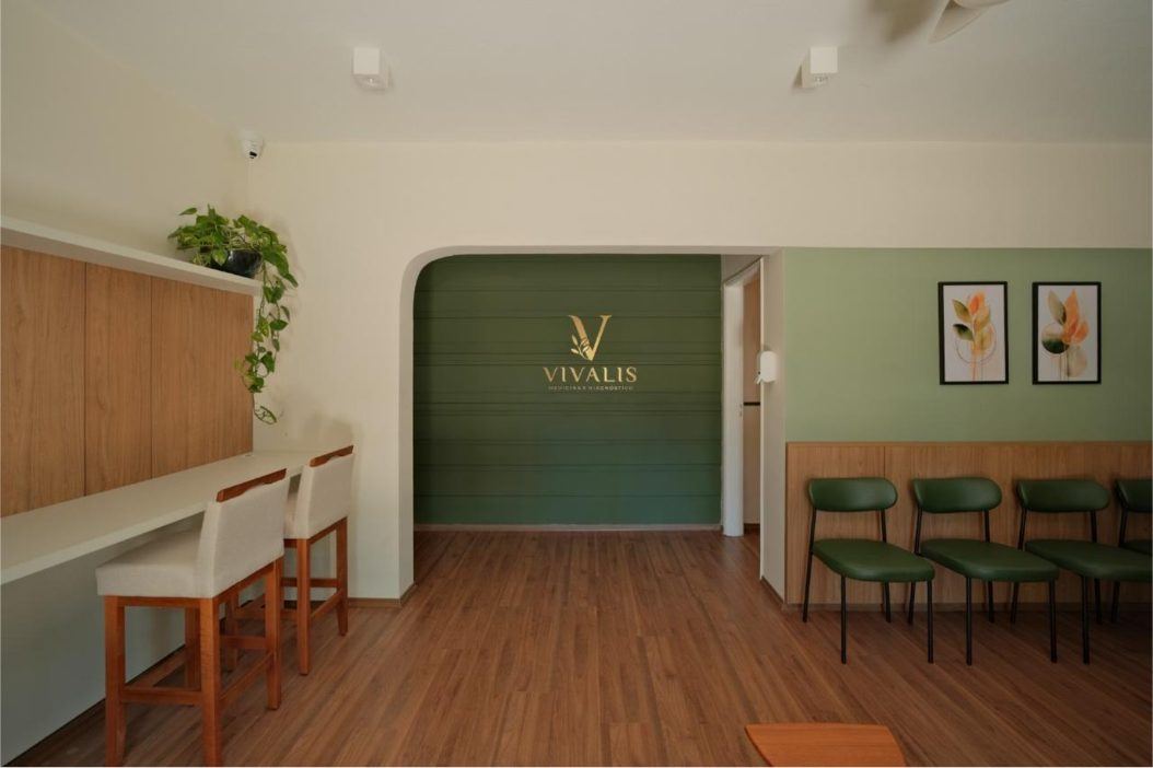Recepção da Vivalis com arco verde e logotipo dourado na parede
